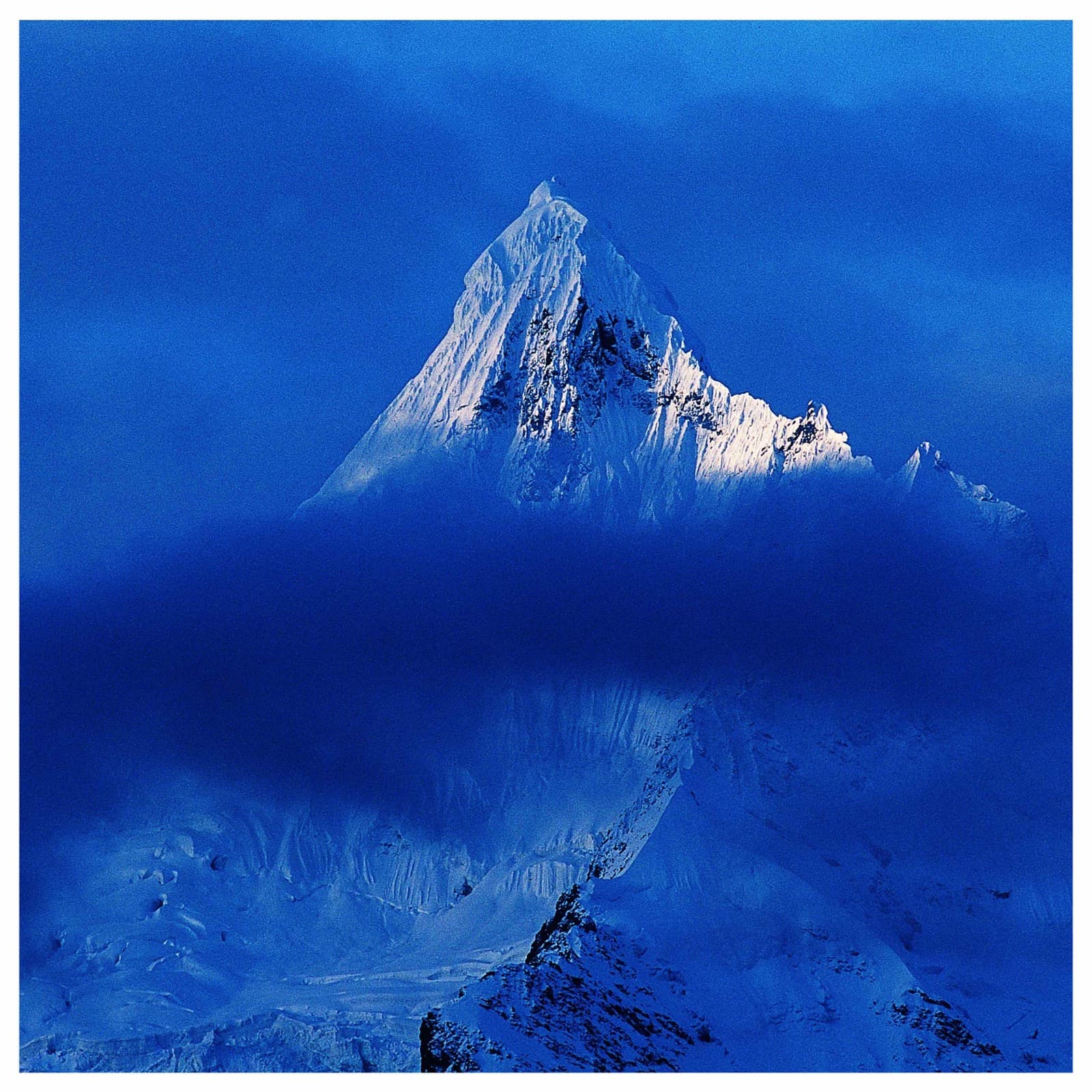 Sacred peak emerging from blue mist