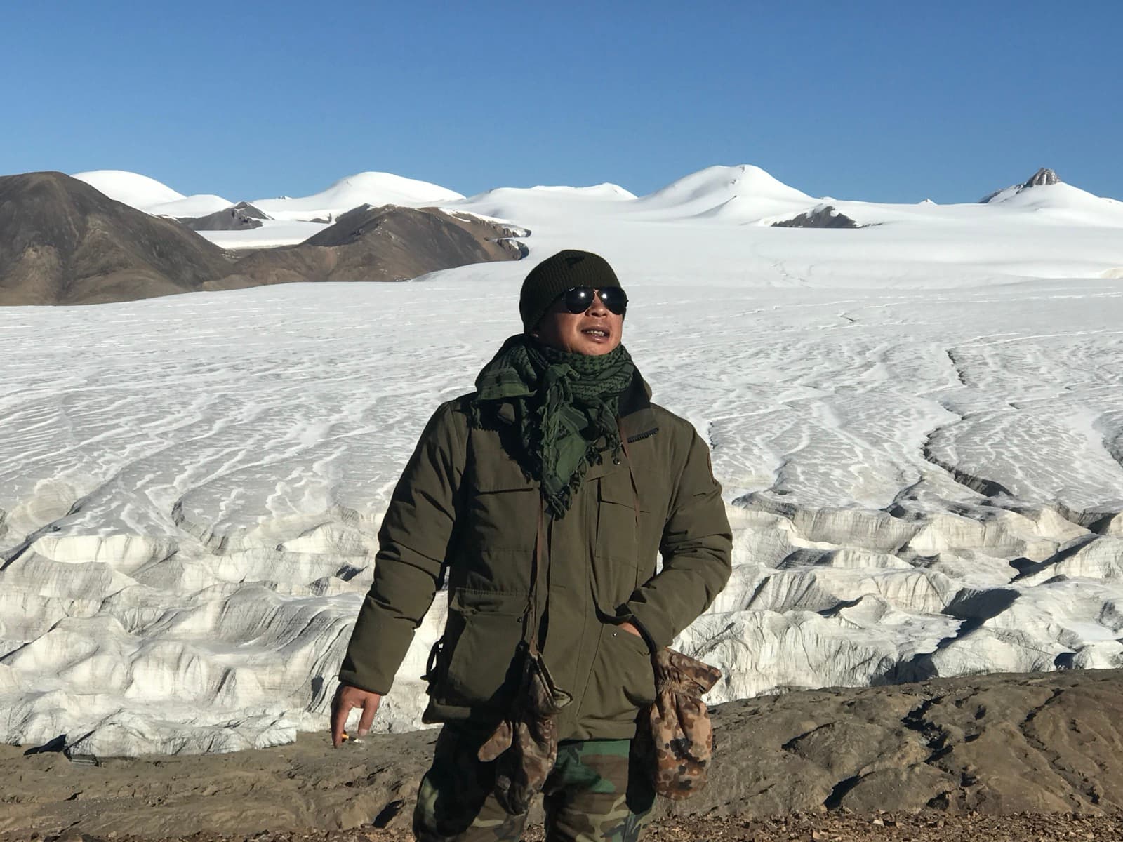 Zheng Yi standing before a glacier